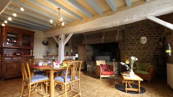 A rustic interior with a dining area, stone fireplace, and wooden furniture.