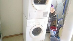 A stacked washer and dryer unit in a laundry room. - Holandsvika Bomiljø (Vefsn)