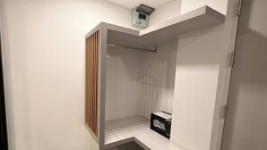 Ein begehbarer Kleiderschrank mit Einbauregal, Kleiderstange und kleiner Aufbewahrungsbox.