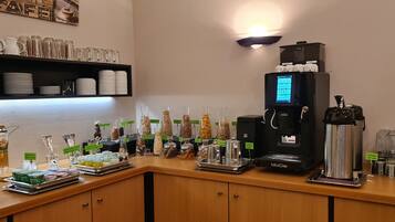 Ein reichhaltiges Buffet mit verschiedenen Speisen, einer Kaffeemaschine und Gläsern.