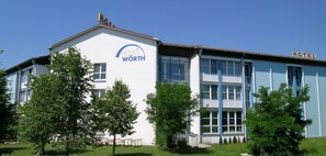 A two-story building with a sign reading "HOTEL WORTH" on the facade. - Hotel Wörth (Woerth an der Isar)