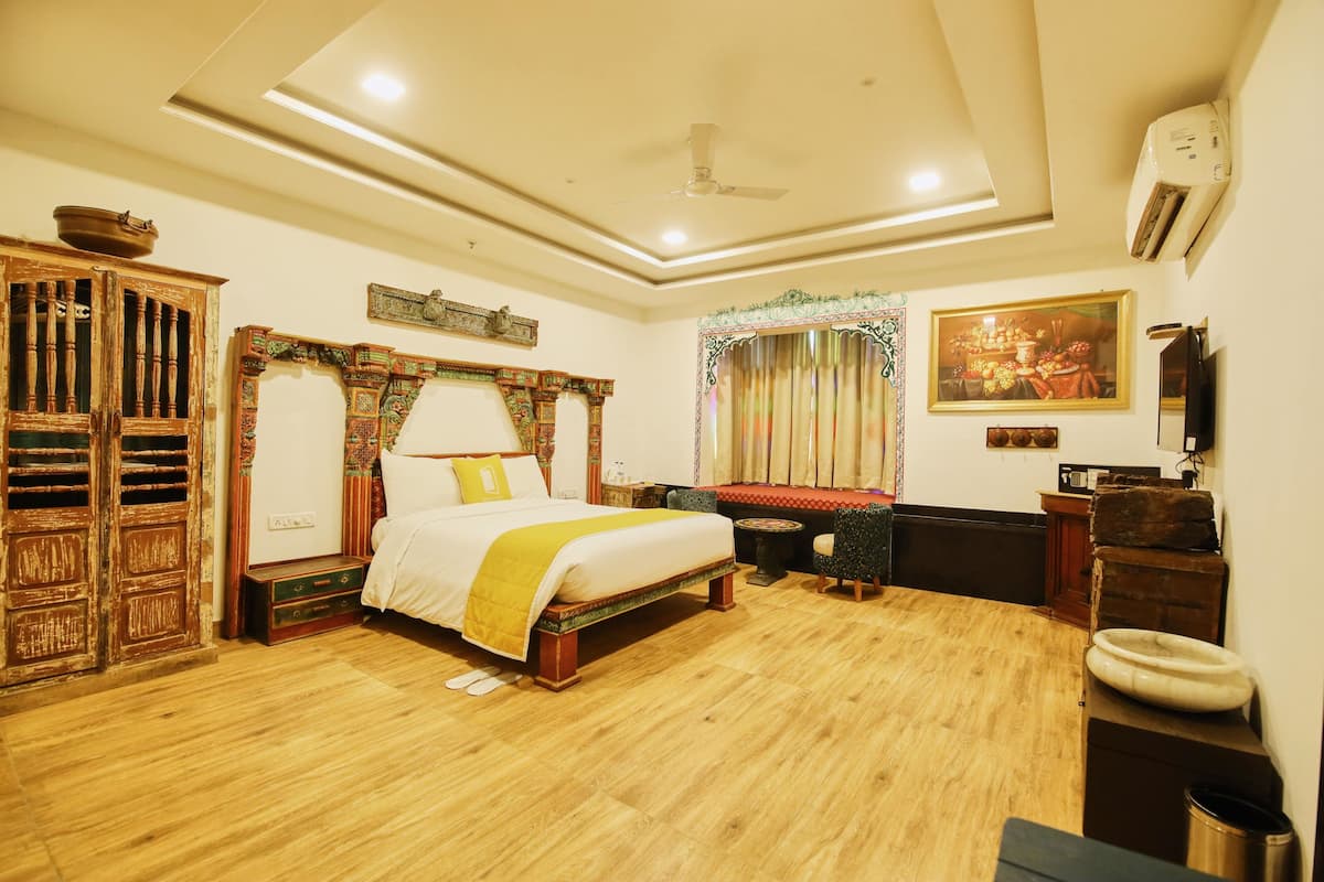 A traditional room with a bed, wooden furniture, and a ceiling fan.