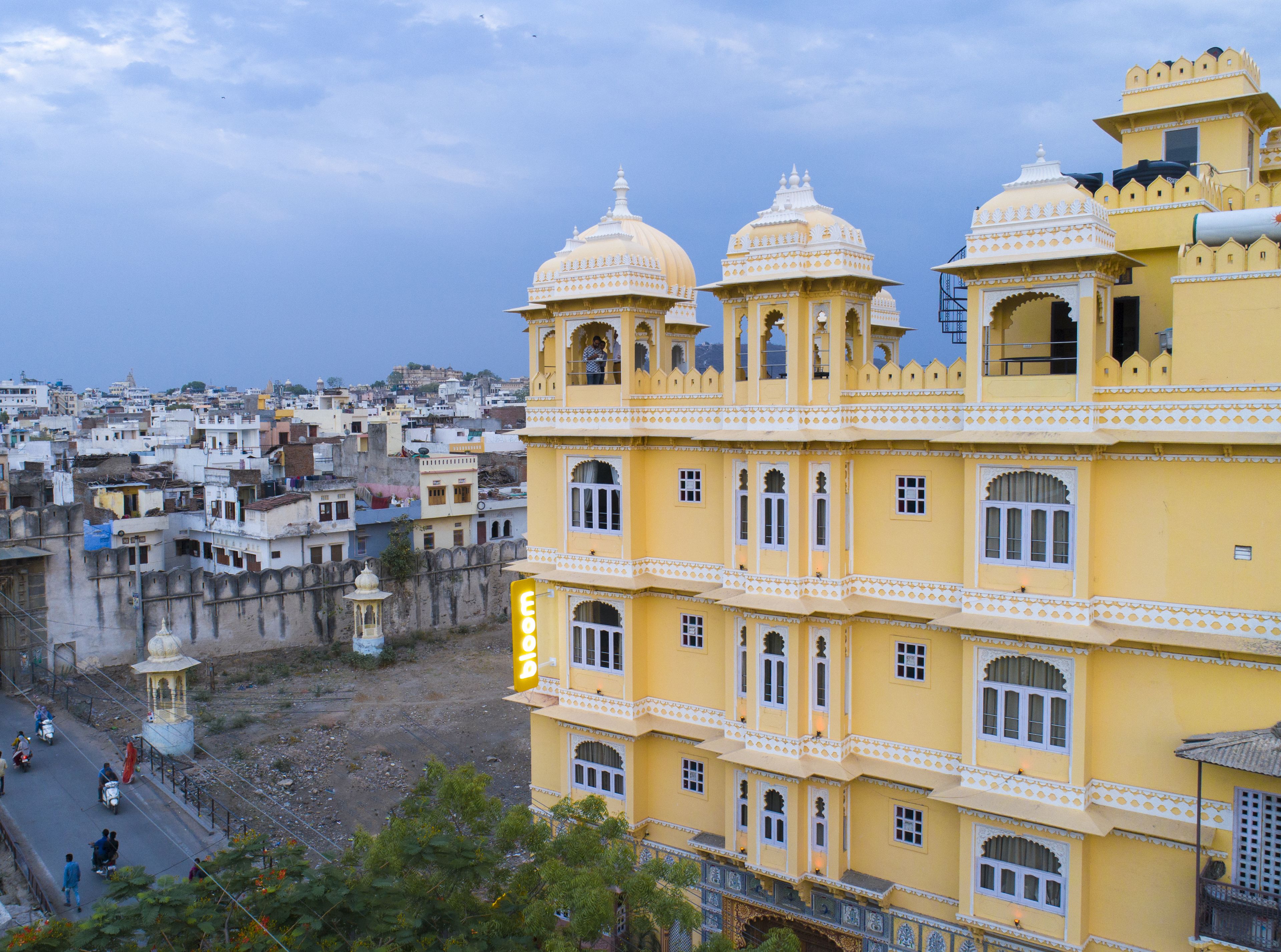 A multi-story yellow building with traditional architecture, including domes and arched windows.