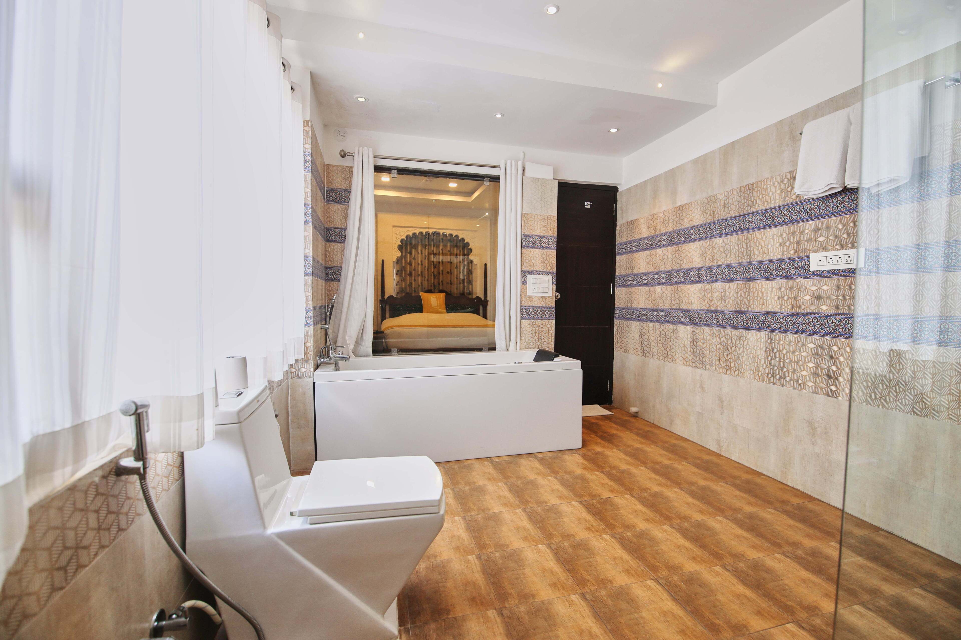 A modern bathroom with a bathtub, toilet, and shower.