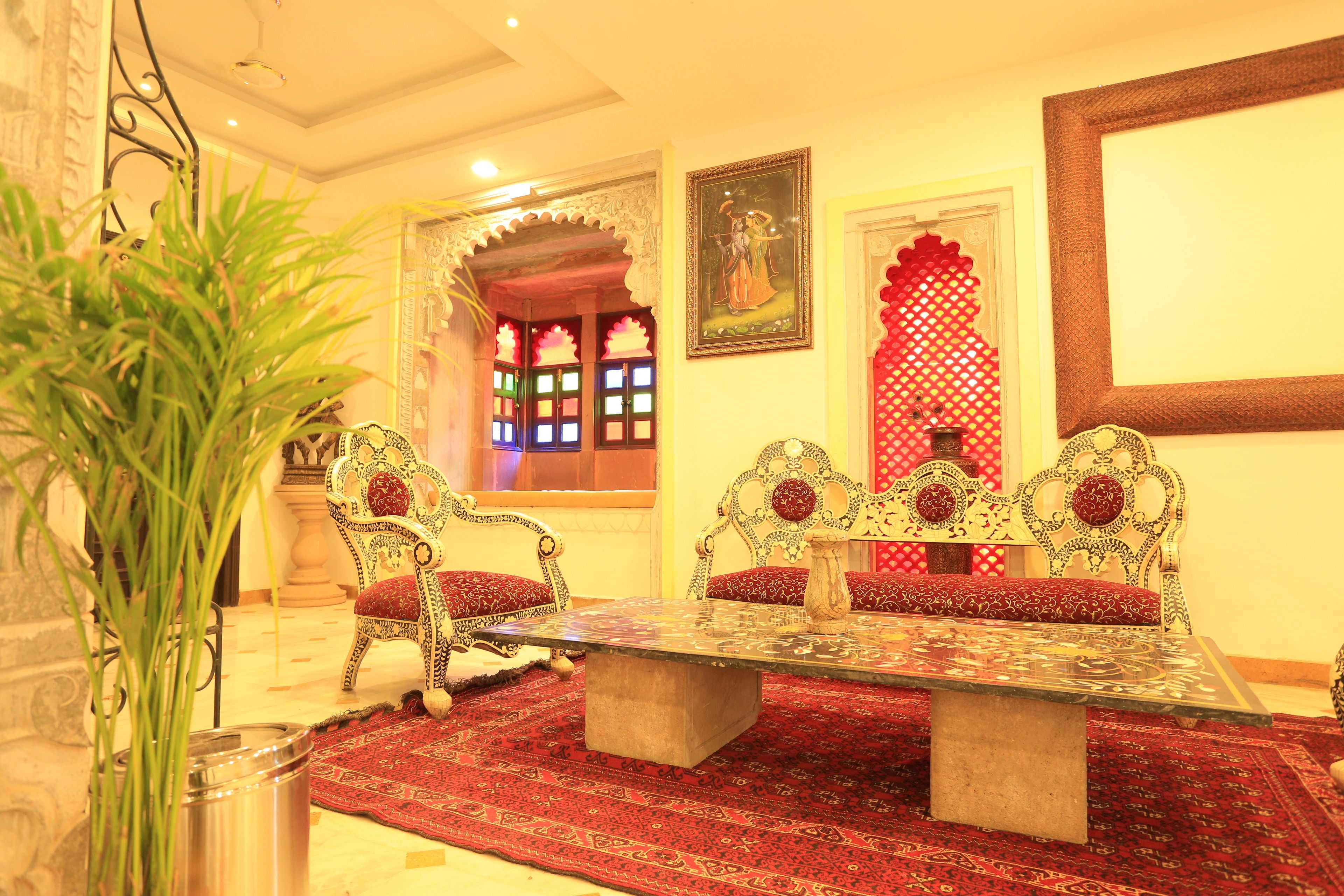A traditional room with ornate furniture, a patterned carpet, and decorative wall elements.