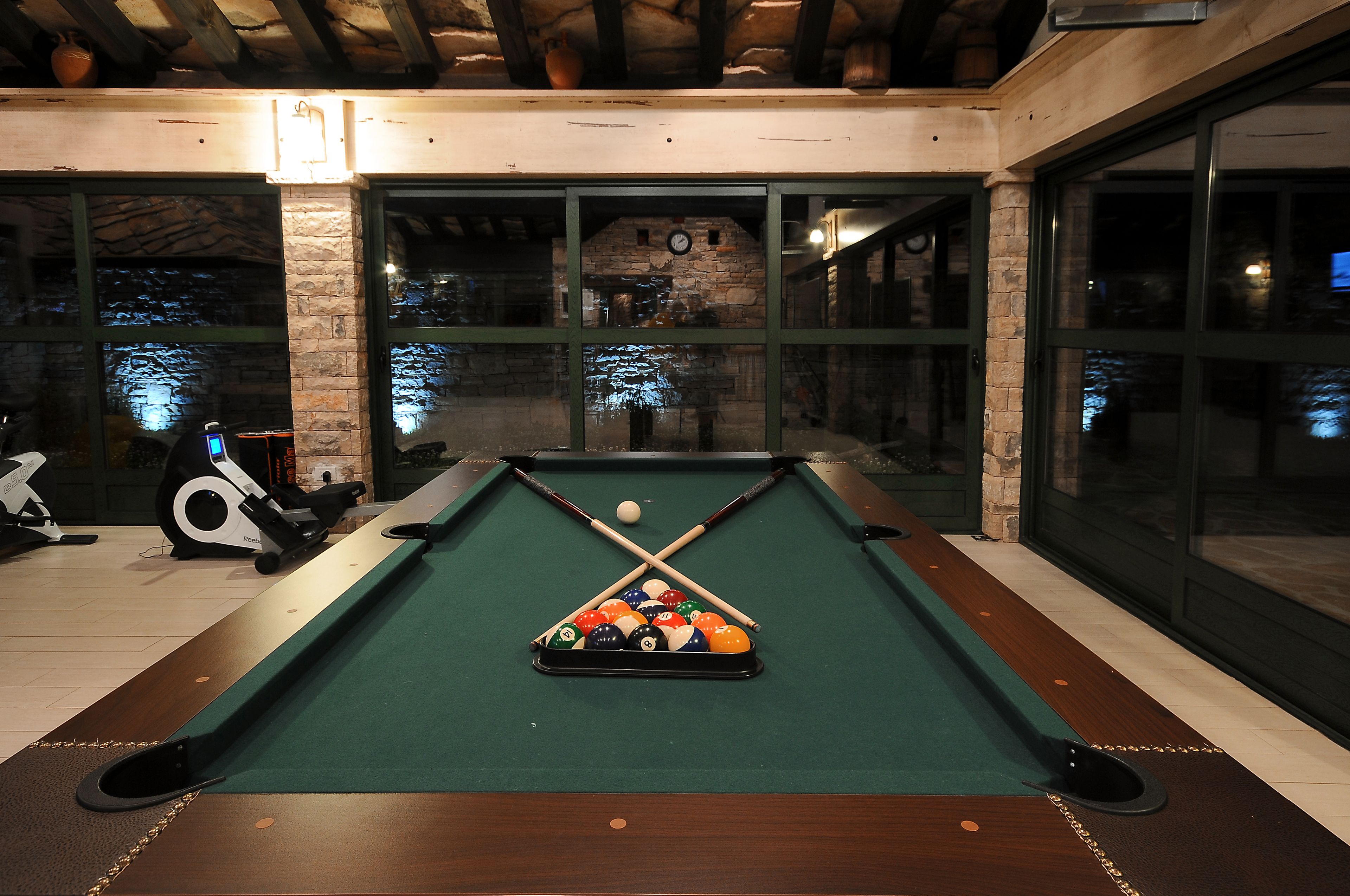 A pool table with a green felt surface, surrounded by a wooden frame.