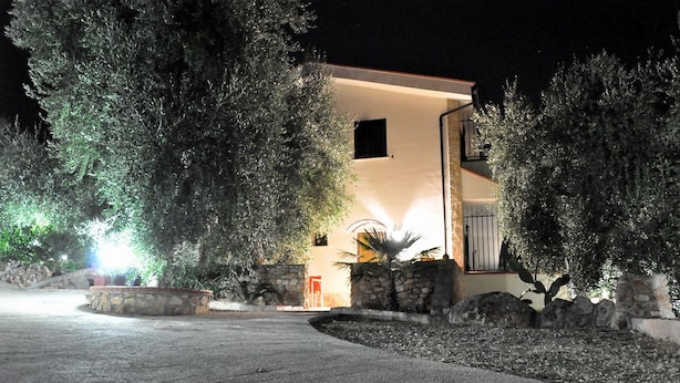 Un edificio moderno con fachada de piedra, un balcón pequeño y una entrada bien iluminada.