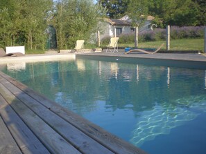 Una piscina al aire libre de temporada, sillones reclinables de piscina