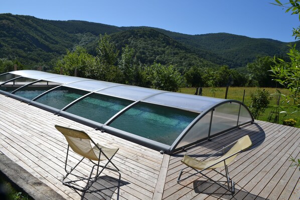 Una piscina al aire libre de temporada, sillones reclinables de piscina