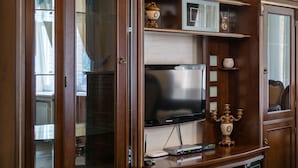 Ein Holz-Unterhaltungsschrank mit einem Flachbildfernseher, einem DVD-Player und einem dekorativen Kerzenleuchter.