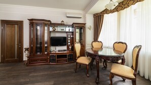 Ein formeller Speisesaal mit einem Holzschrank, einem Fernseher und vier Stühlen.