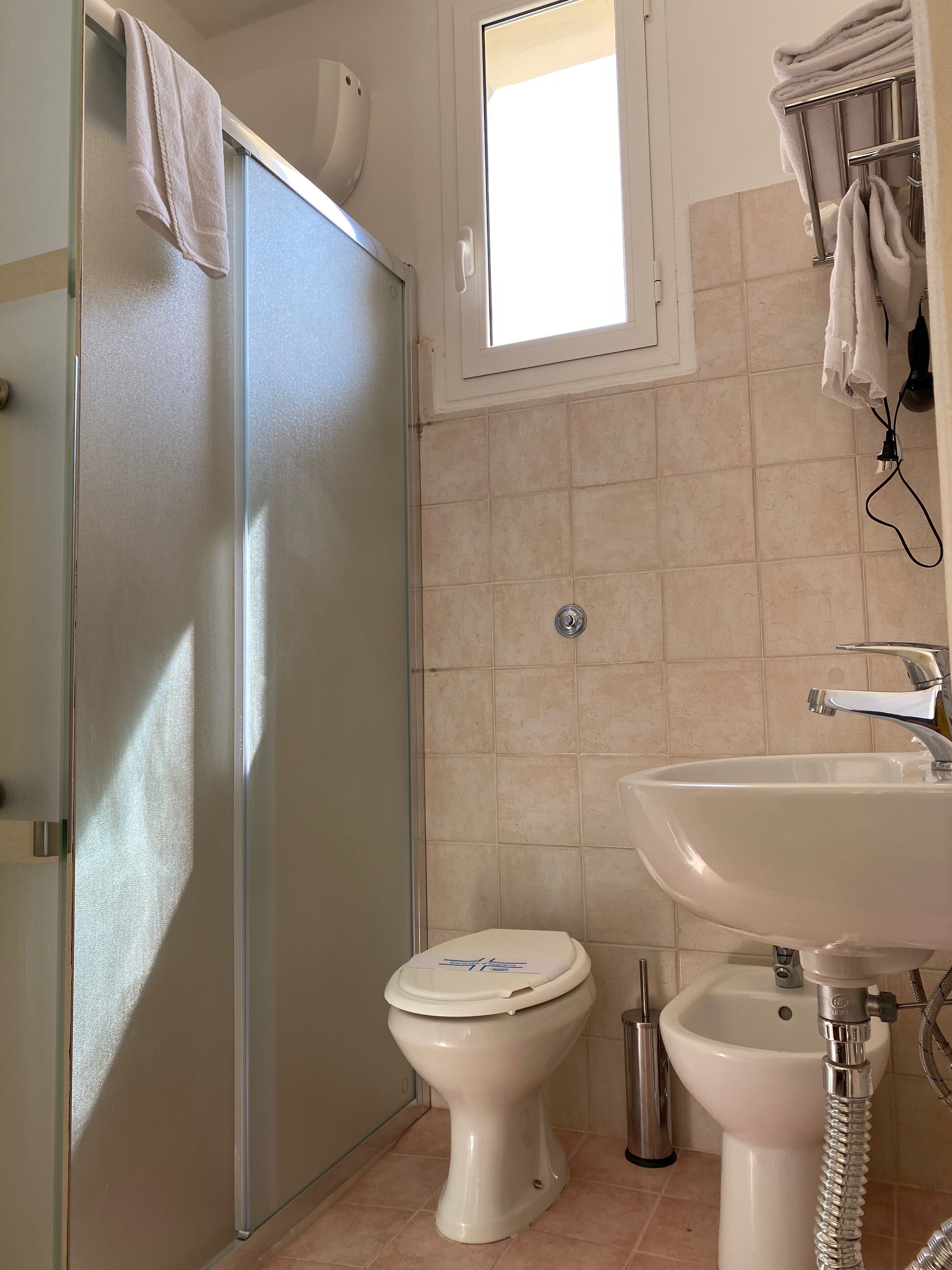 A bathroom with a toilet, sink, and shower.