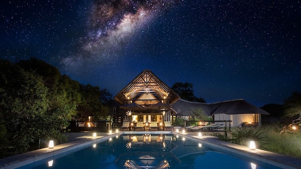 A hotel with a swimming pool, a large open area, and a starry night sky. - Vuyani Safari Lodge (Hoedspruit)