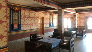 Una habitación con paredes estampadas, una puerta de madera y un mantel a cuadros.