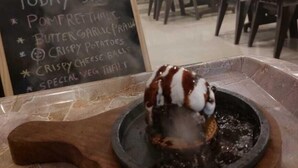 A dessert presentation in a restaurant setting with a chalkboard menu listing specials. - Royal Paradise Hotel (Alibag)