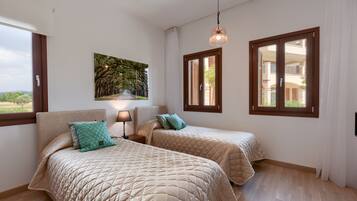 Un dormitorio con dos camas, una mesita de noche, una lámpara, un cuadro y una ventana con contraventanas.