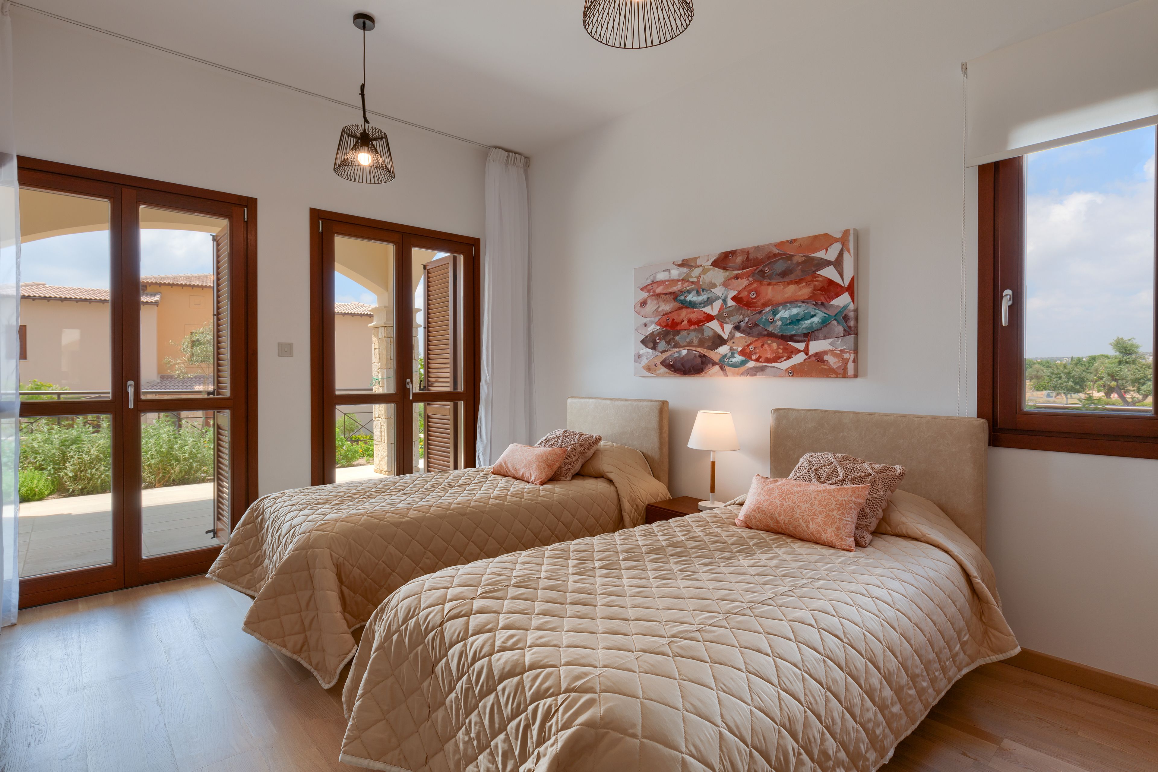 Quarto com duas camas, uma janela grande e vista para o exterior.