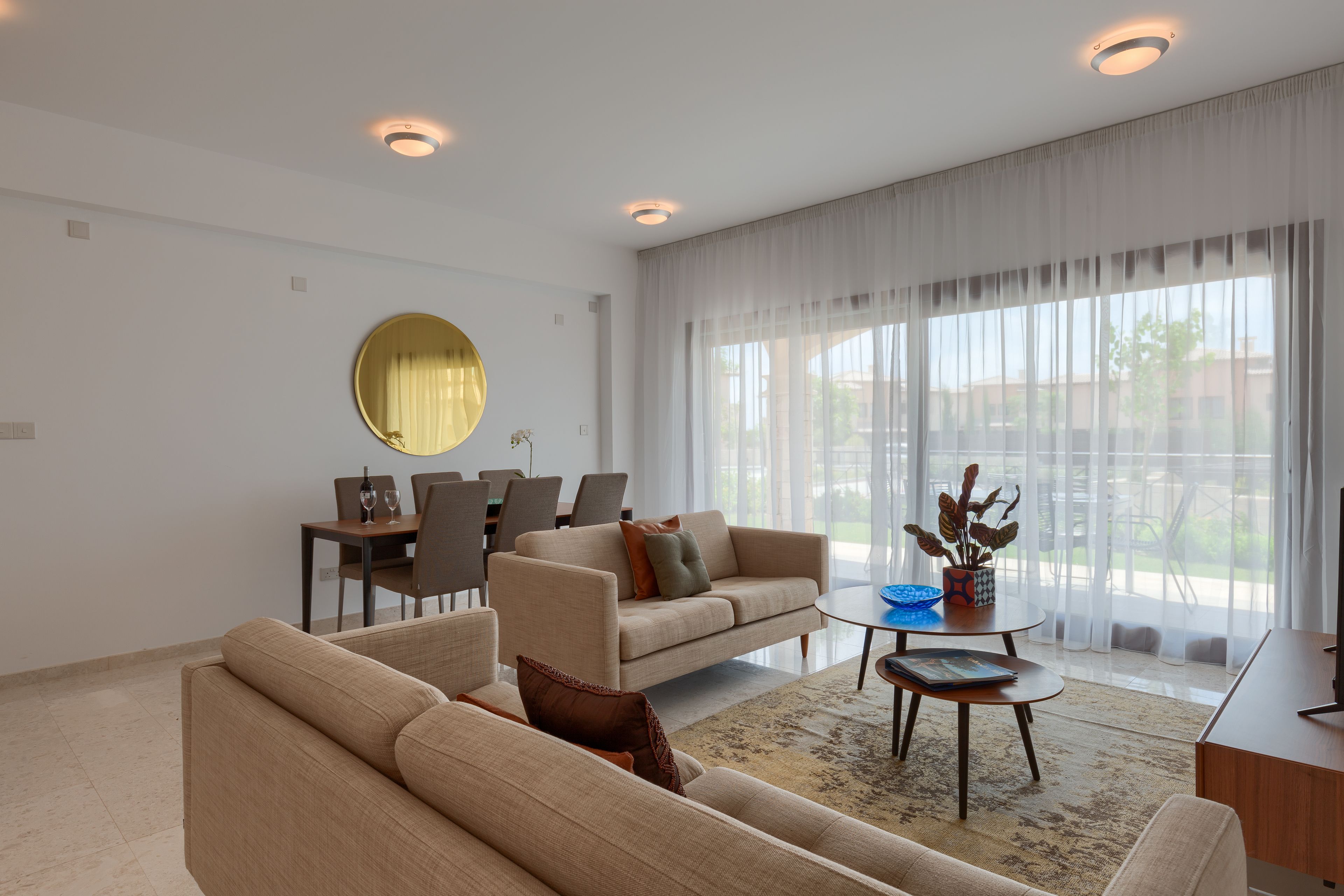 A modern living room with a sofa, coffee table, and dining area.