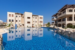 Outdoor pool, pool umbrellas, pool loungers - Aphrodite Hills Rentals – Premium Serviced Apartments (Kouklia)
