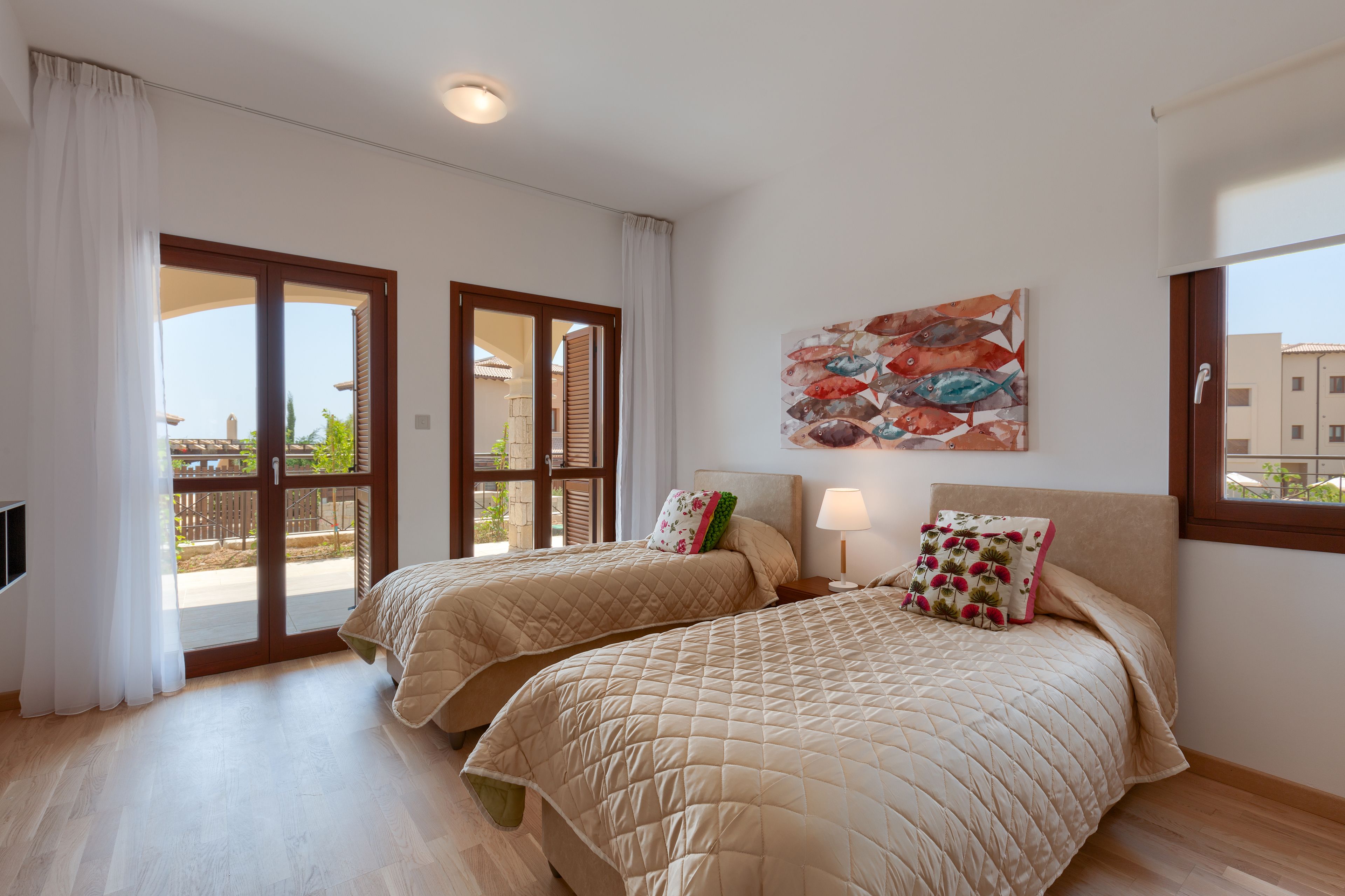 Una habitación de hotel con dos camas, un ventanal grande y vistas al exterior.