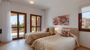 Una habitación de hotel con dos camas, un ventanal grande y vistas al exterior.