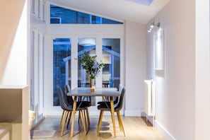 Enjoy meals with family and friends in this dining area, featuring a large window with a city view.