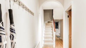 A hallway with a staircase leading to a room with a window. - The Modern Classic - Contemporary & Elegant 3bdr Home (Cambridge)