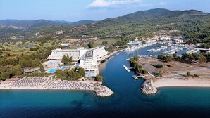 Un hotel a la costa amb diverses piscines, un port esportiu i una zona de platja.