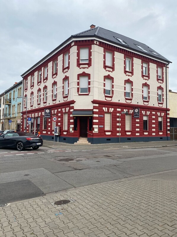 A red and white building with multiple windows and a signboard.