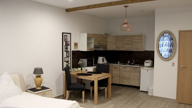 Quarto compacto com cama, escrivaninha e cozinha compacta.