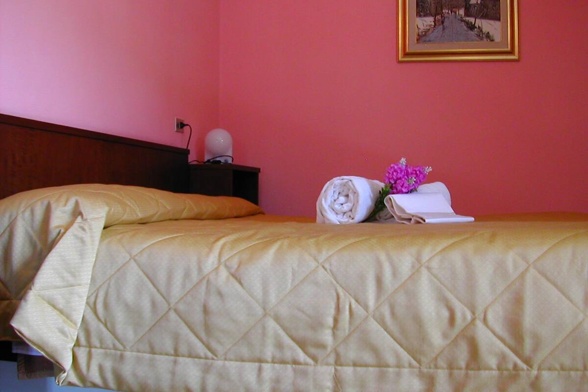 Une chambre d’hôtel avec un lit, une table de chevet, une lampe et un tableau au mur.