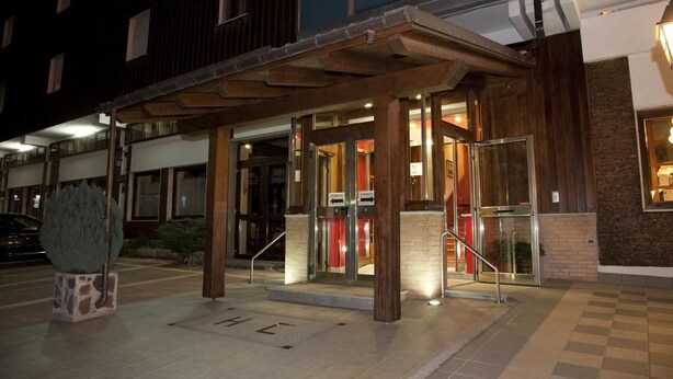 A hotel entrance with a covered entrance area, glass doors, and a staircase leading to the entrance. - Hotel Cristallo (Spezzano della Sila)