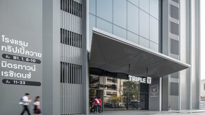Ein moderner Hotelzugang mit einer großen Glasfassade und einem überdachten Eingangsbereich.