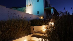 Un bâtiment moderne à la façade blanche, doté de nombreuses fenêtres et d’un balcon.