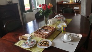 A dining table set with food and drinks, a vase with flowers, and a window in the background. -  Vigna dell'Agrifoglio Home Residence di Eugenio Azzolini (Velletri)