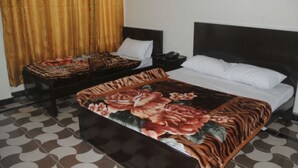 A hotel room with a large bed, a bedside table, and a chair. - Hotel River side and Restaurant (Swat)