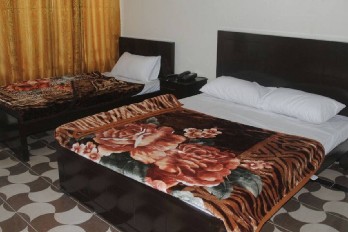 A hotel room with a large bed, a bedside table, and a chair.