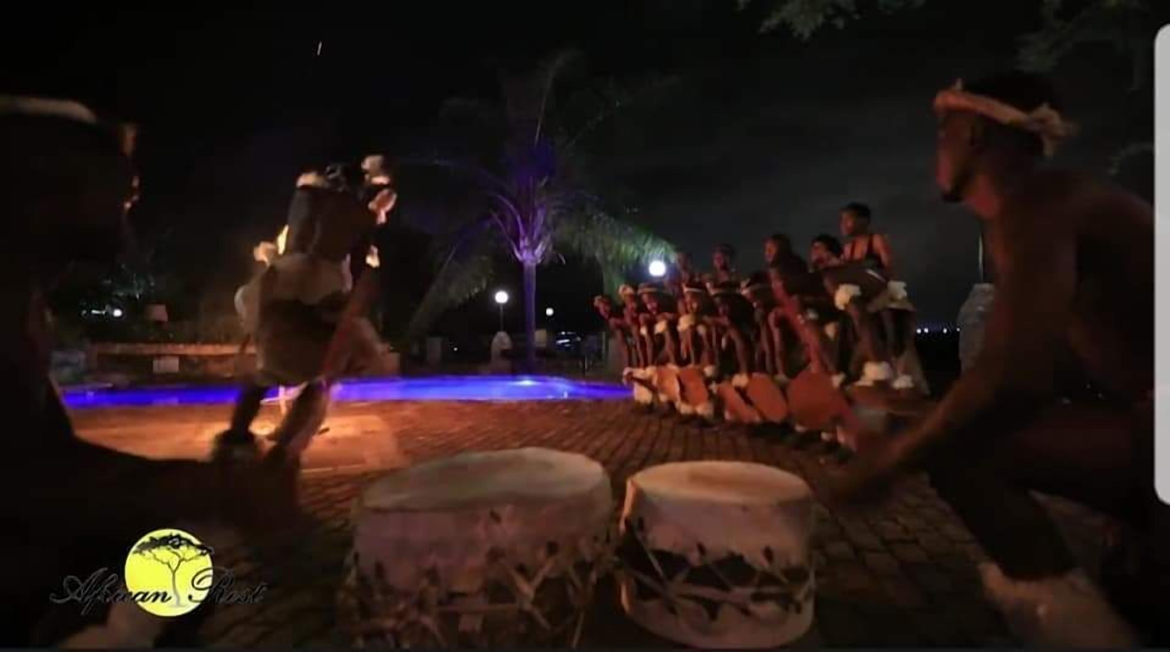 Un grupo de personas bailando una danza tradicional al aire libre por la noche.