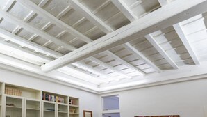 Une pièce dotée d’une lucarne, de bibliothèques et d’un tableau encadré.
