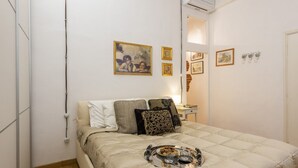 Une chambre à coucher avec un lit, un plateau contenant des aliments pour le petit-déjeuner et plusieurs tableaux encadrés accrochés au mur.