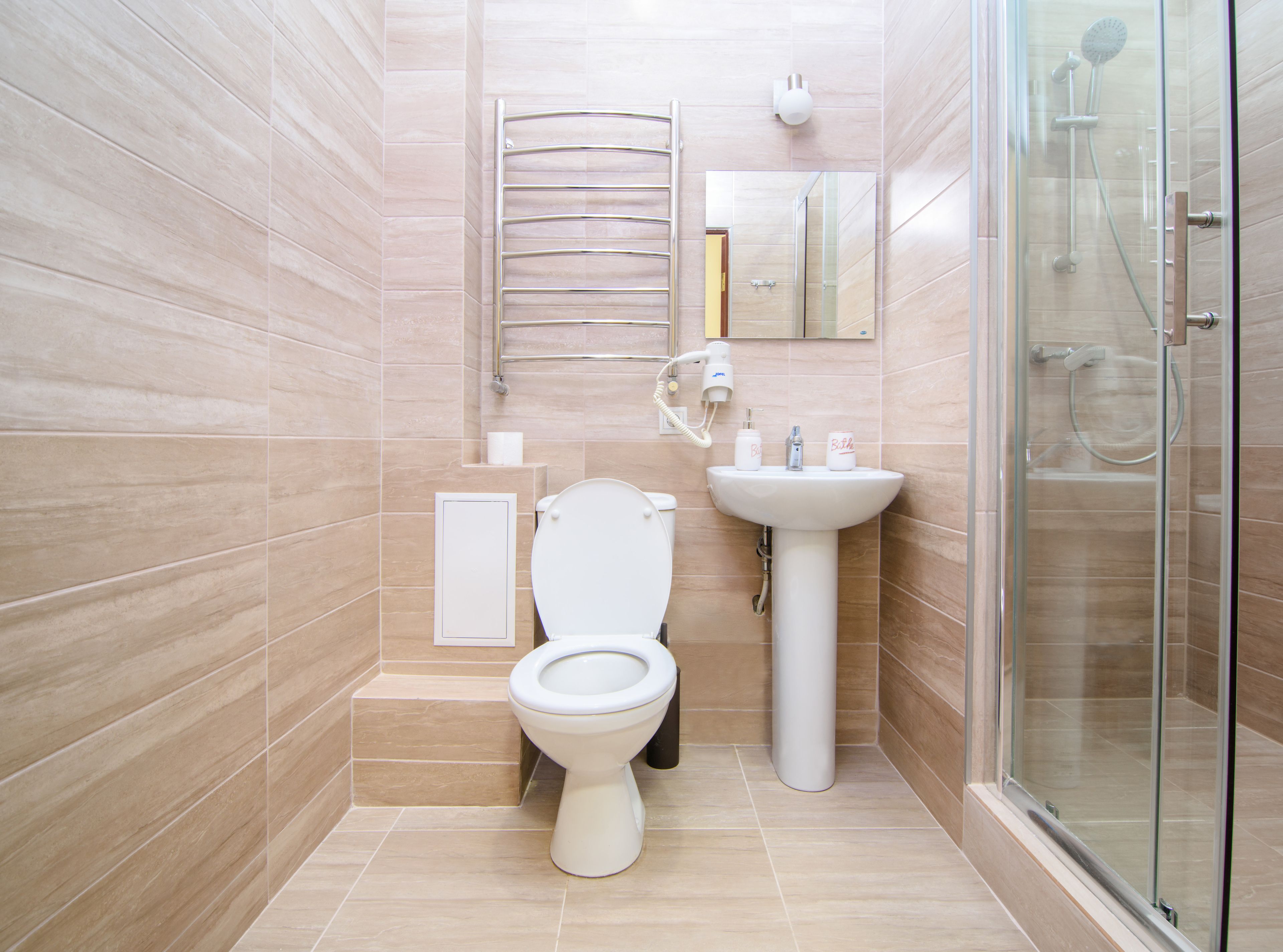 Ein modernes Badezimmer mit Toilette, Waschbecken und einer Duschkabine aus Glas.