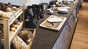 Un comptoir de boulangerie où l’on trouve une variété de pains, de pâtisseries et des bocaux remplis d’ingrédients.