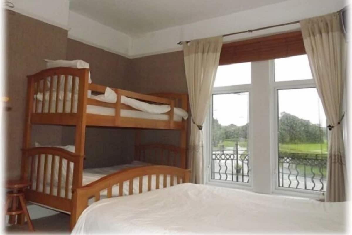 A bunk bed room with a large window and curtains.