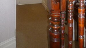 A staircase with wooden balusters and a handrail, leading to a door with a stained glass window. - Manor View Guest House (Whitby)