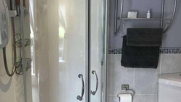Ein modernes Badezimmer mit einer Duschkabine, einer Toilette und einem Handtuchhalter.