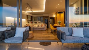 Un salon moderne avec un ensemble de canapés, un coin repas et une cuisine en arrière-plan.