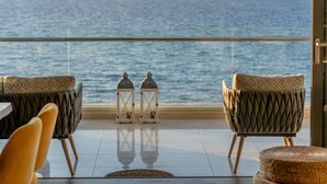 Un balcon avec deux fauteuils en osier, une petite table et deux lanternes.
