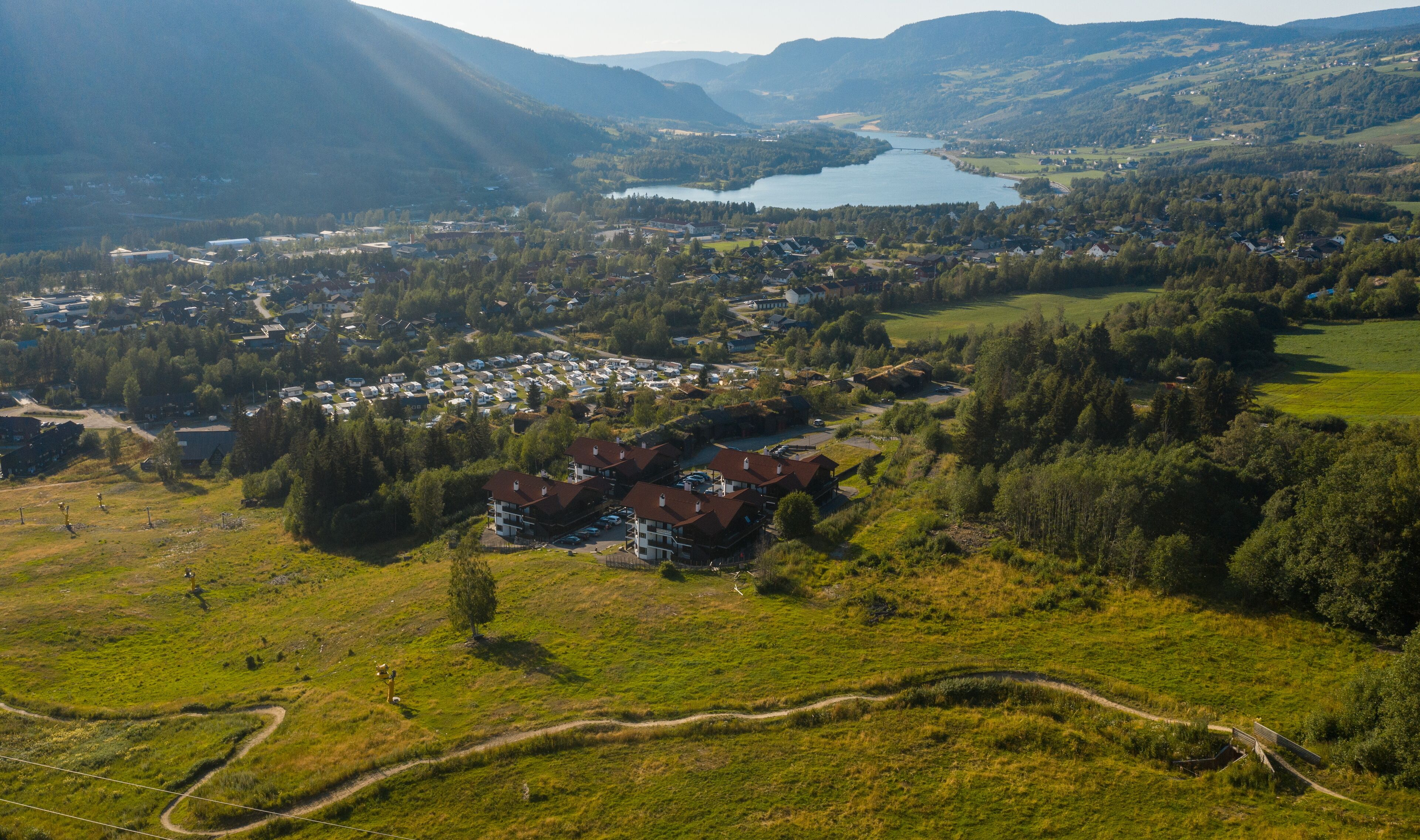 An aerial view of a town with a river, surrounded by hills.