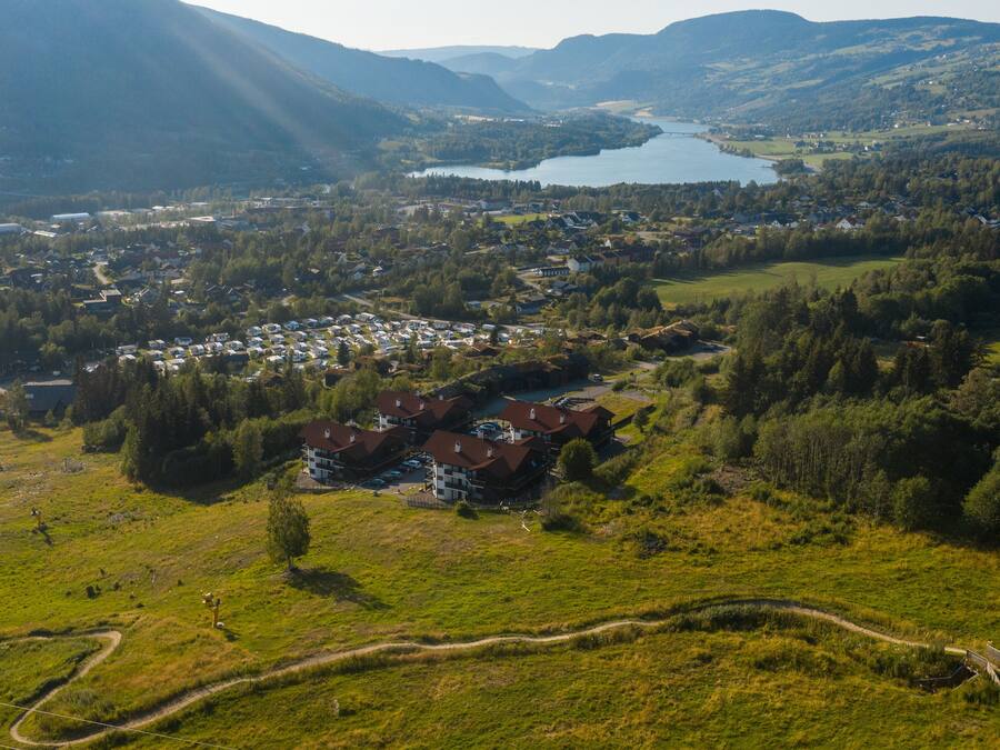 An aerial view of a town with a river, surrounded by hills.