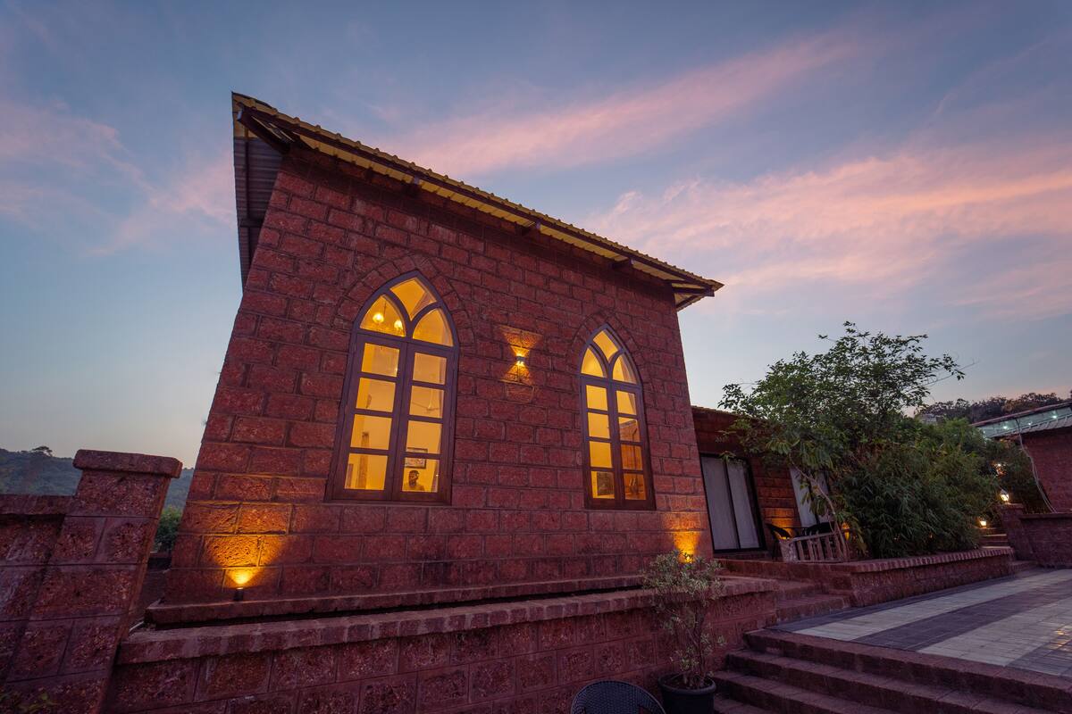 A brick building with two arched windows and a small balcony.